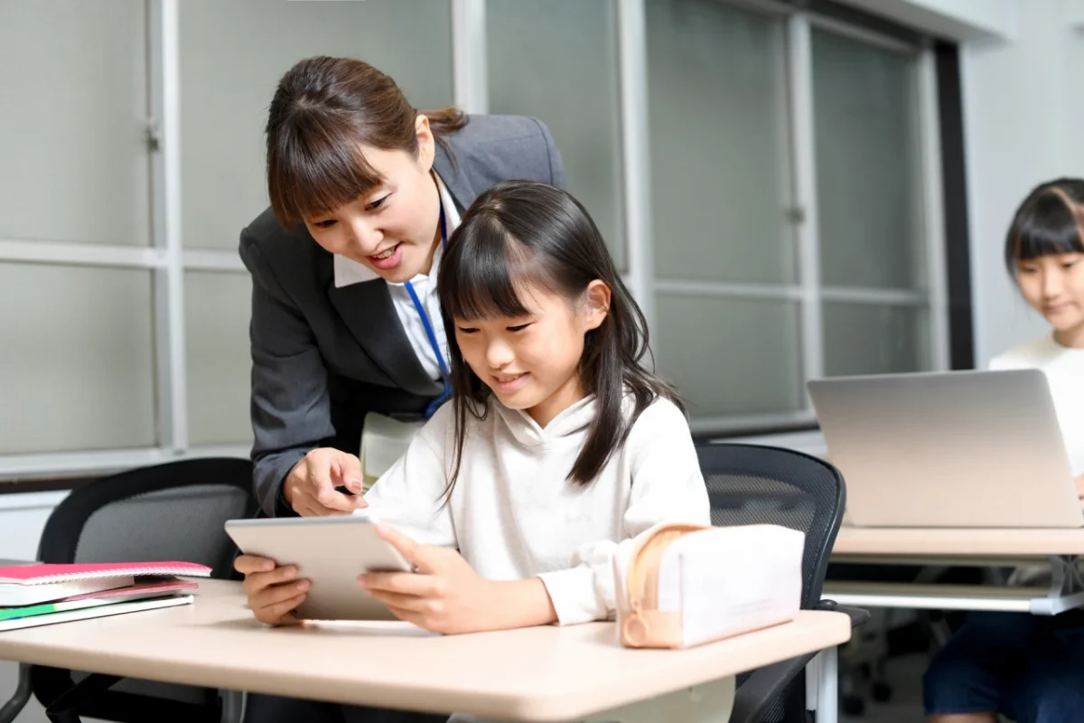 学校でタブレットを使って授業を受ける小学生